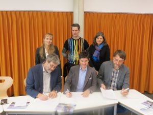 Vertragsunterzeichnung mit der Neunlindenschule. v. li. n. re vorne: Rektor Matthias Auer, Prof. Dr. Lars Holzäpfel, Prof. Dr. Wolfgang Hochbruck, hinten Jessica Ohletz, Andreas Andrick, Susanne Bremer