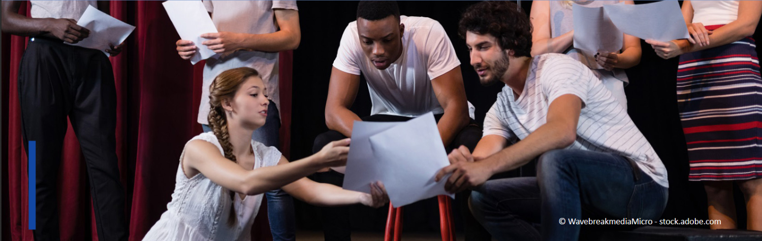 Sieben junge Menschen stehen auf einer Theaterbühne und erarbeiten gemeinsam den Text bzw. die Szene.