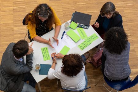 Participants of a meeting with the partner schools are brainstorming and taking notes on green cards