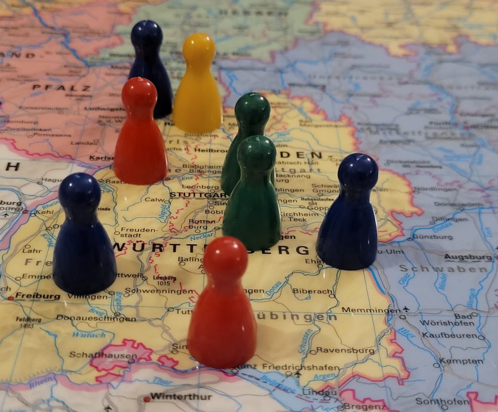 Auf einer Landkarte von Baden-Württemberg stehen verteilt bunte Spielfiguren