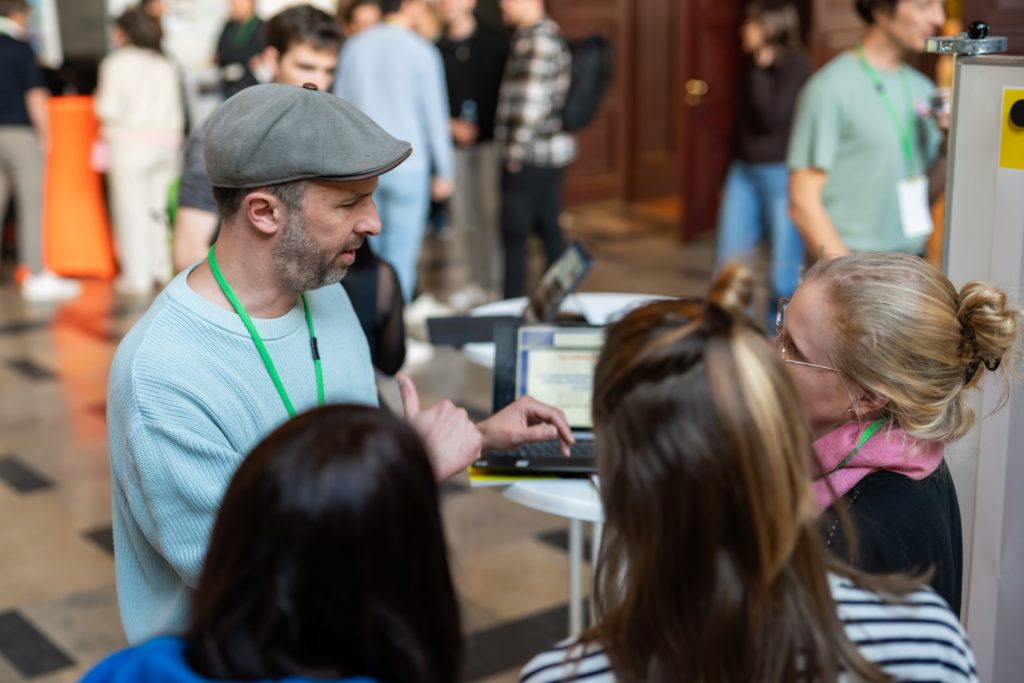 Drei Junglehrerinnen tauschen sich mit einem Mann beim Infostand aus