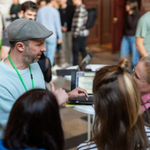 Drei Junglehrerinnen tauschen sich mit einem Mann beim Infostand aus