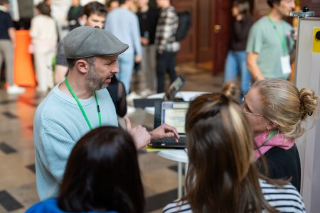 Drei Junglehrerinnen tauschen sich mit einem Mann beim Infostand aus