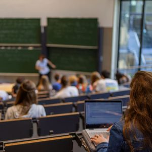 Blick von hinten in einen Hörsaal während einer Vorlesung