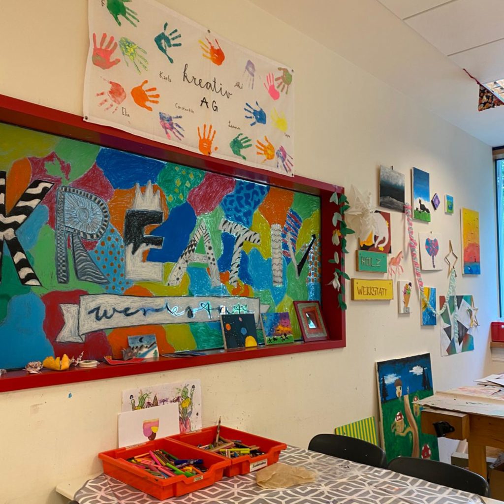 Aufenhtaltsraum der Ganztagsbetreuung mit vielen bunten Bildern der Kreativ AG an der Wand