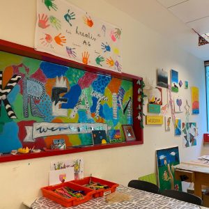 Aufenhtaltsraum der Ganztagsbetreuung mit vielen bunten Bildern der Kreativ AG an der Wand