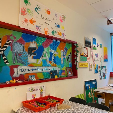 Aufenhtaltsraum der Ganztagsbetreuung mit vielen bunten Bildern der Kreativ AG an der Wand
