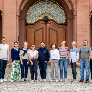 Die zwölf Teilnehmenden des Netzwerktreffens stehend lächelnd vor dem Schloss der Universität Mannheim.