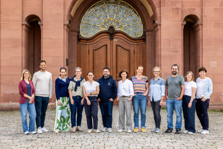 Die zwölf Teilnehmenden des Netzwerktreffens stehend lächelnd vor dem Schloss der Universität Mannheim.